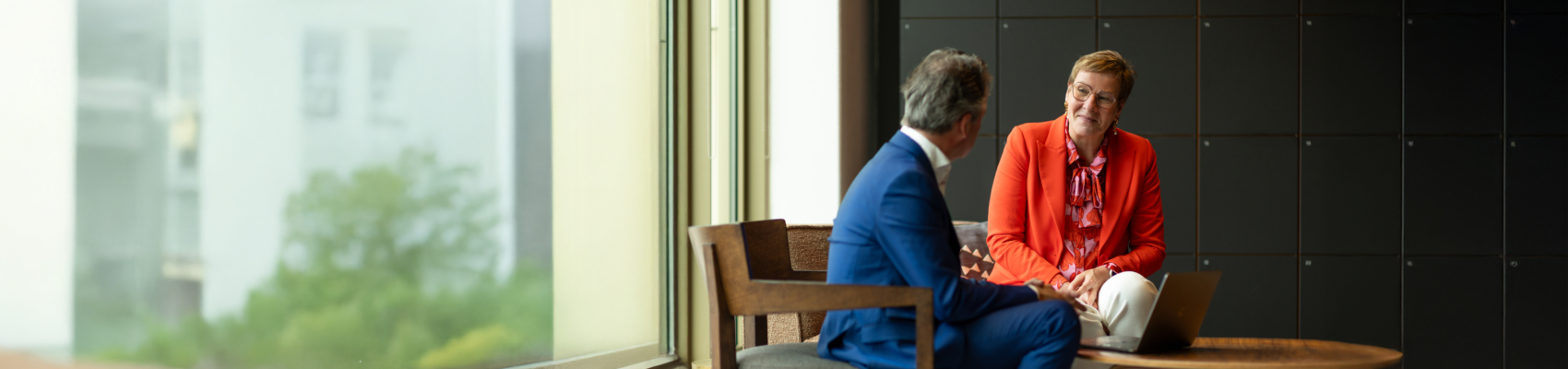 Twee collega's hebben een fysieke meeting op kantoor